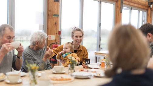 A lady with a baby eating in the cafe at Tinkley Gate
